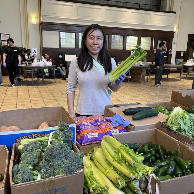 woman holds a veggie at the food bank